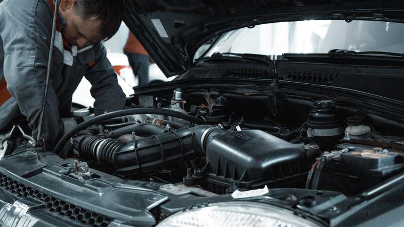 Diverse team working on cars in a clean garage workshop